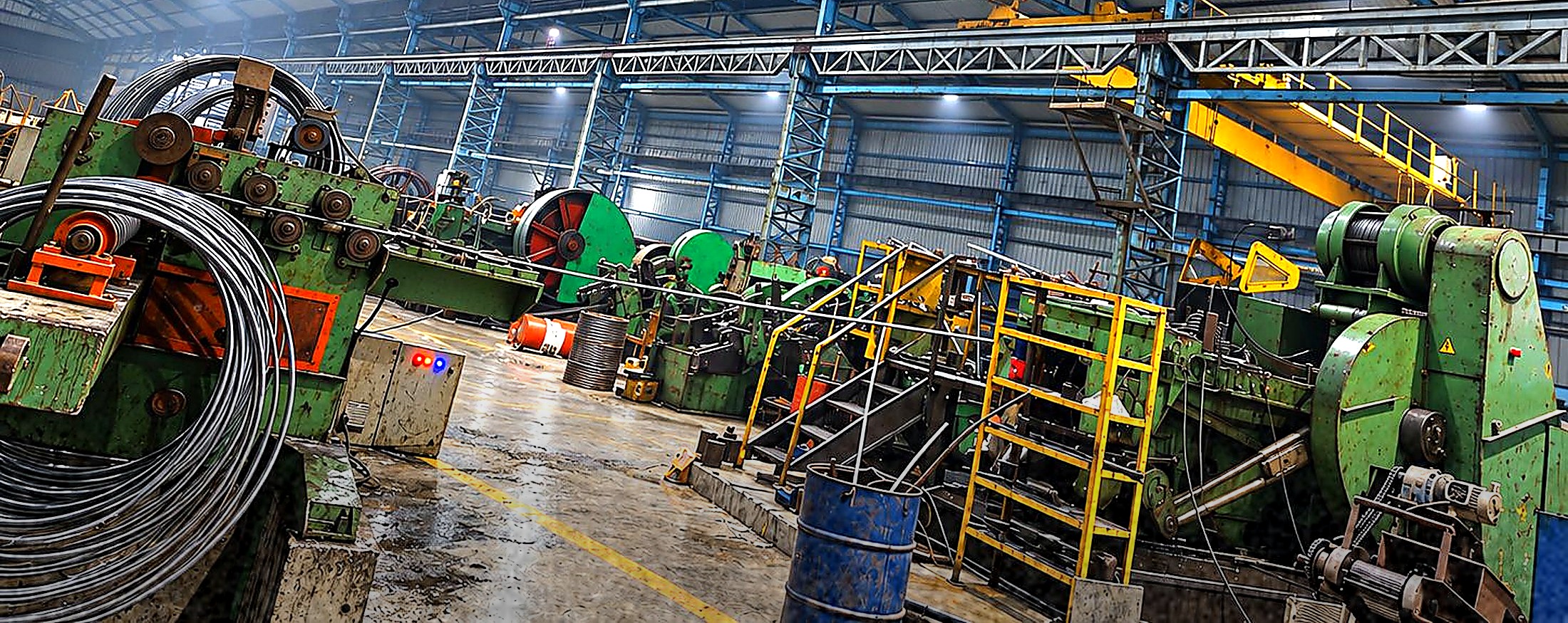 Green multi-station cold forging machinery on the shop floor